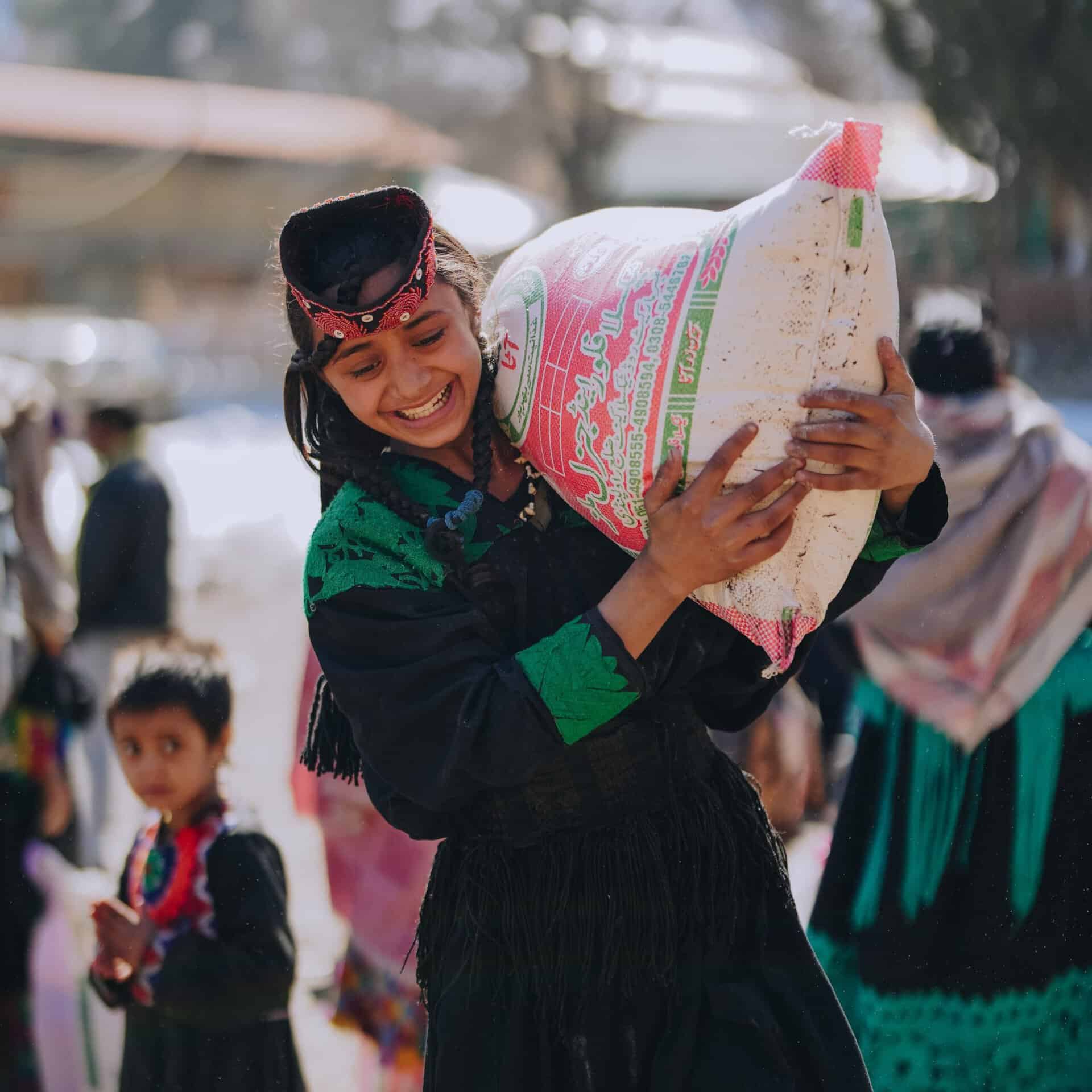 A woman receives groceries in Pakistan