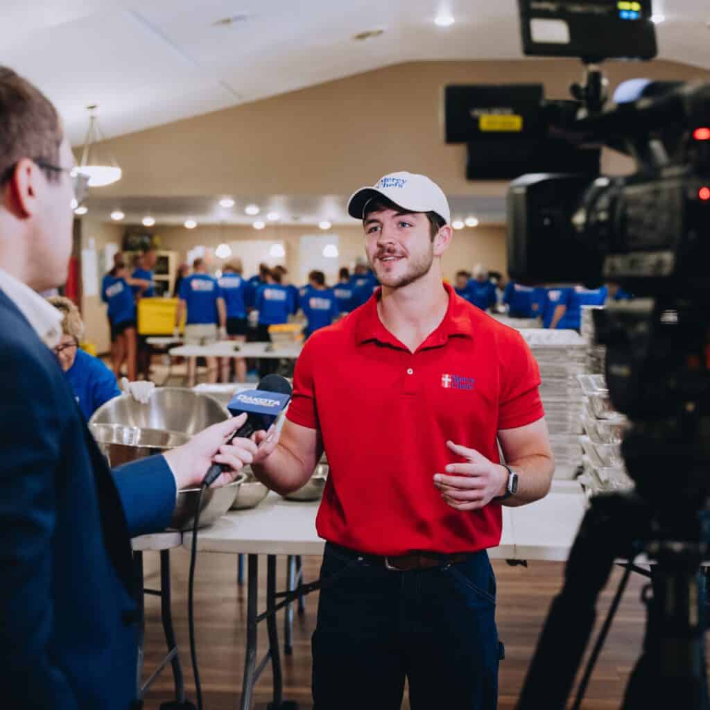 A reporter interviews Raymond LeBlanc on the ground