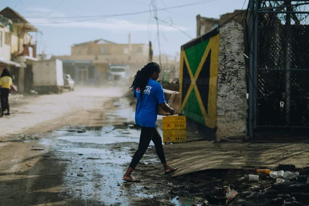 A volunteer in Jamaica delivers hot meals to Hurricane Melissa victims
