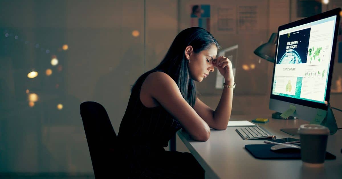Woman sitting at desk suffering from stage 3 adrenal exhaustion