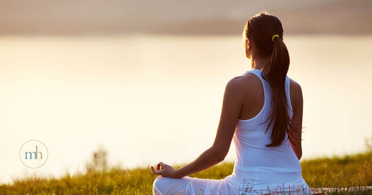 Woman meditating to manage stress and fatigue.