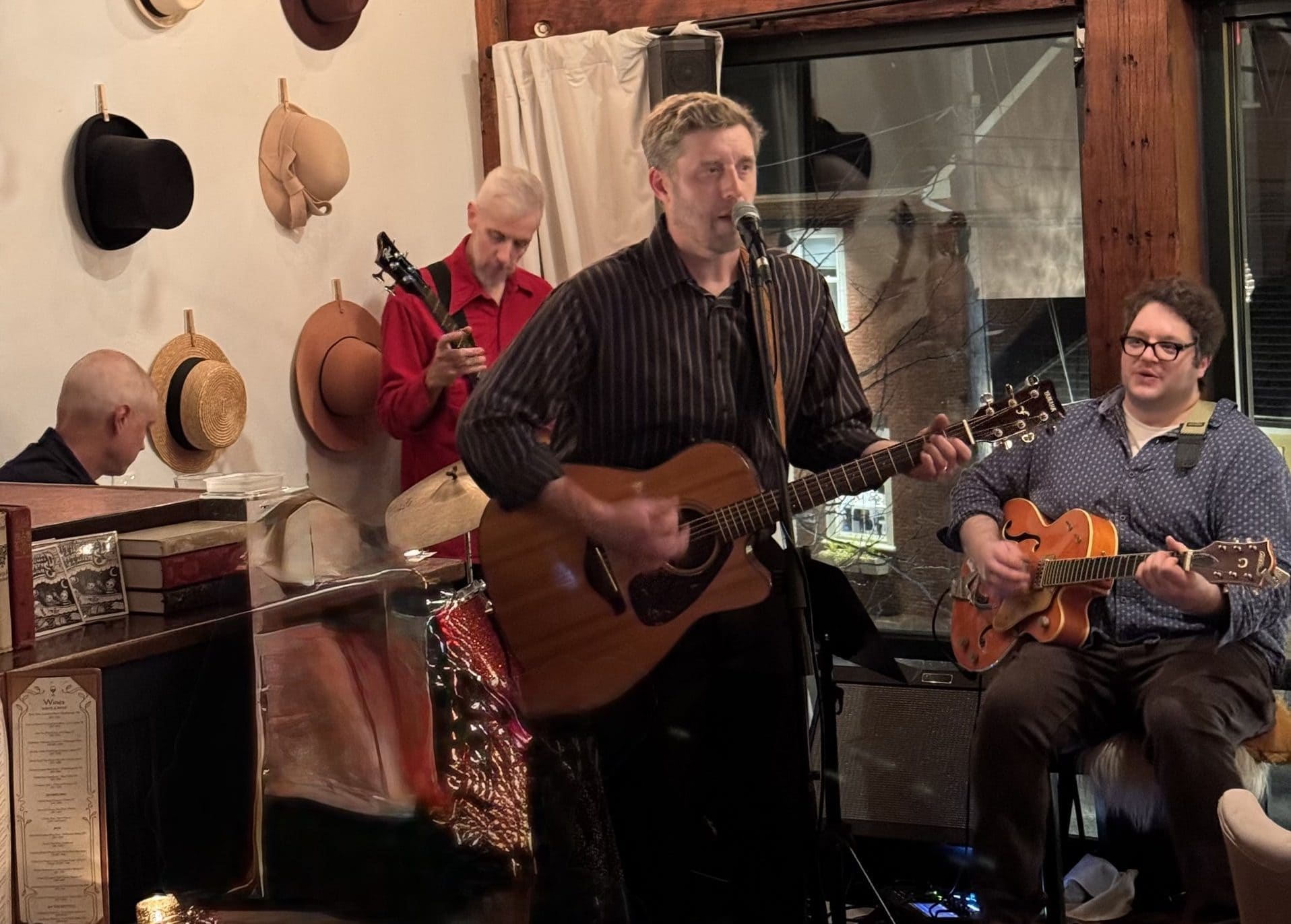 Live music performance at Michael's Harborside with three musicians playing guitars and singing.
