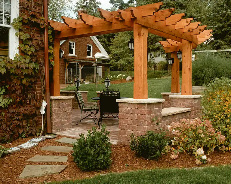 Pergola with wooden beams and brick pillars for outdoor fencing and shade.