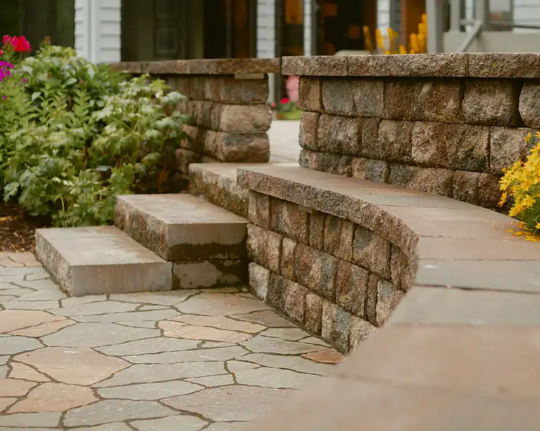 Durable stone steps leading to a garden entrance with landscaping.