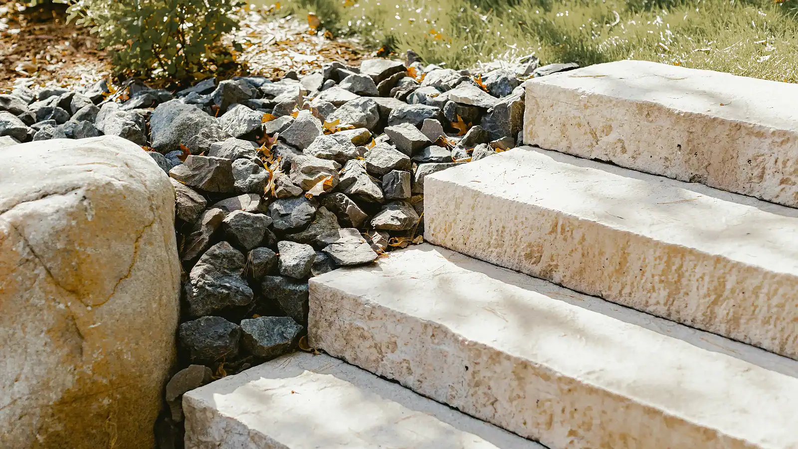 Stone steps and rock landscaping in a yard setting.