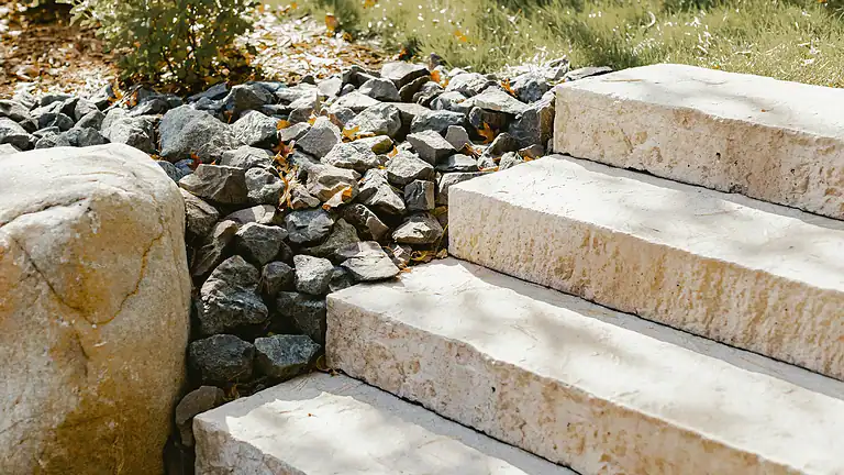 Stone steps and rock landscaping in a yard setting.