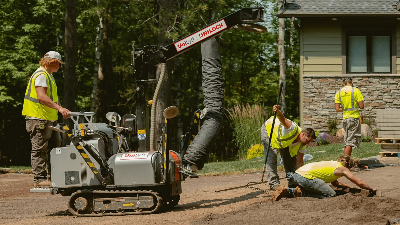 Excavation work with compact machinery and team members in safety vests.