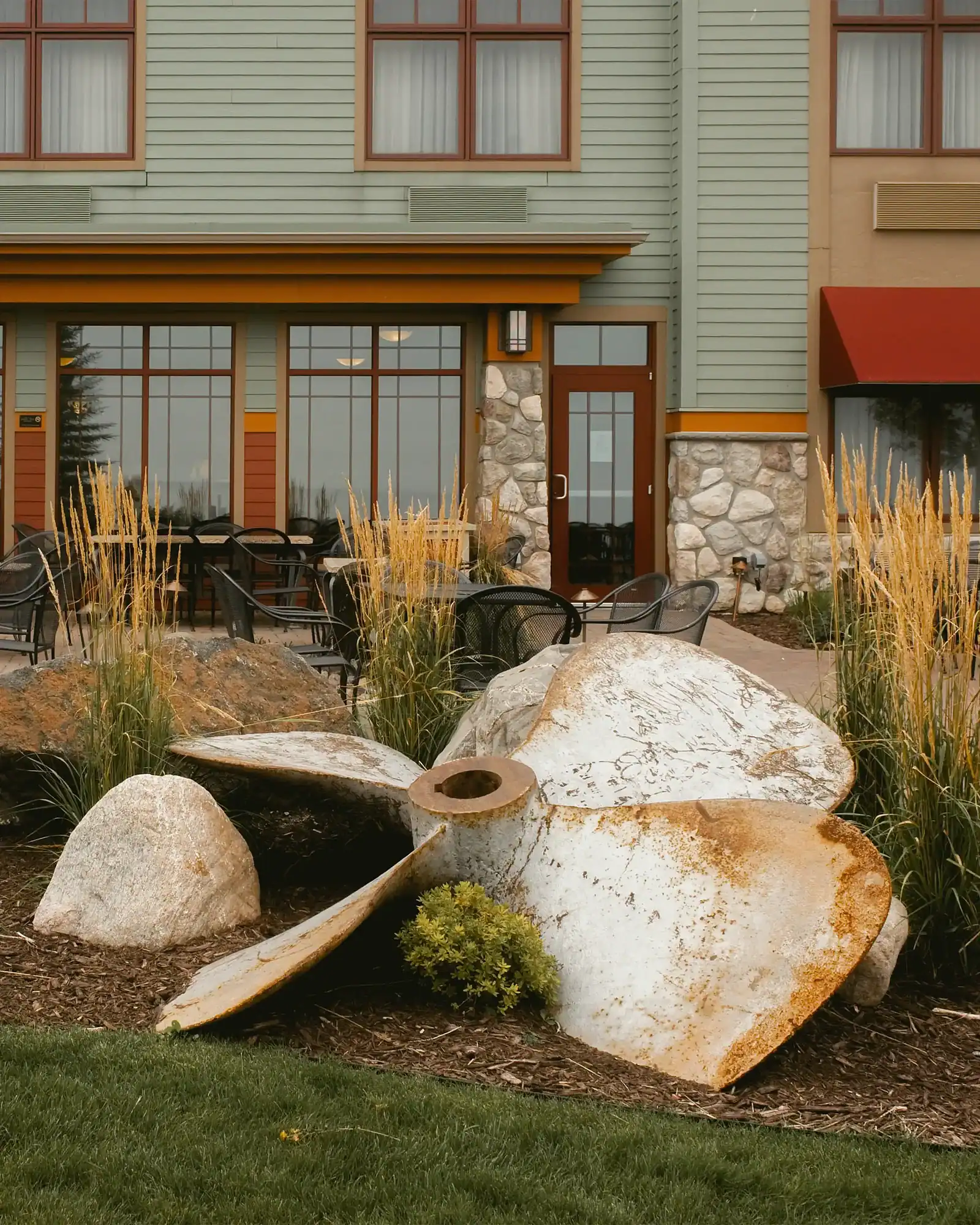 Contemporary home exterior with landscaped garden featuring large rocks and grasses.