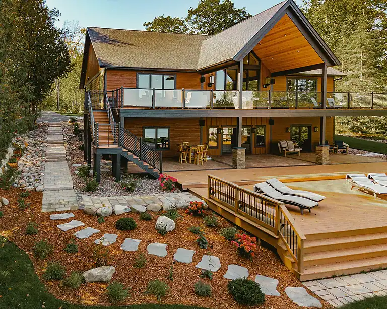 Lakeside Flow at Nebagamon with a modern house, deck, and landscaped yard. Perfect for relaxing by t.