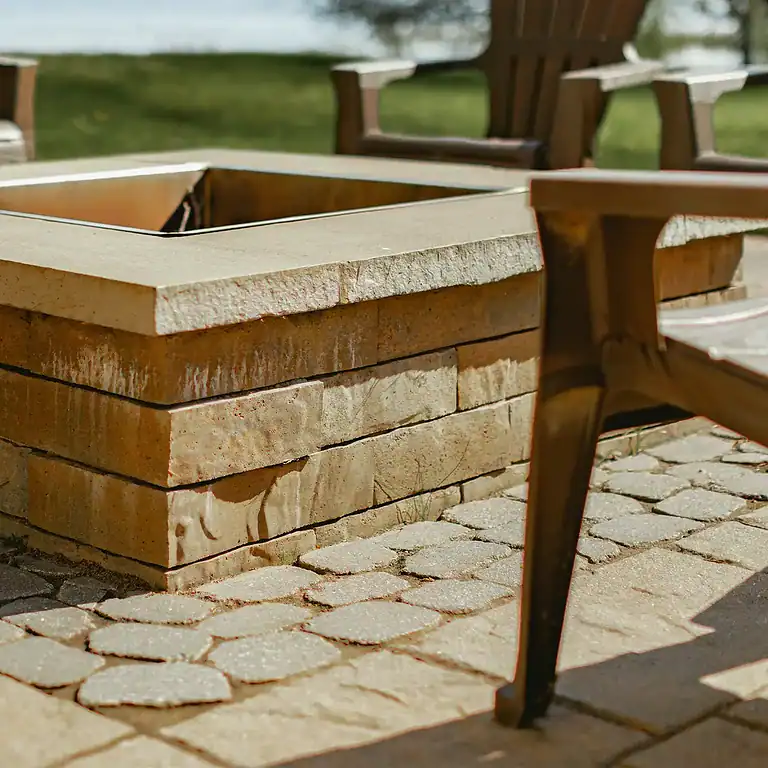 Fire pit with stacked stone design and wooden seating area by the lakeside.