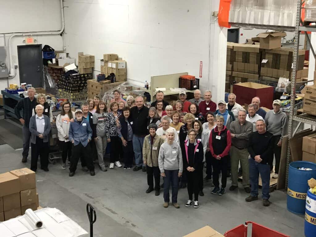 A group of people standing in a warehouse. They are the Hope of East TN.