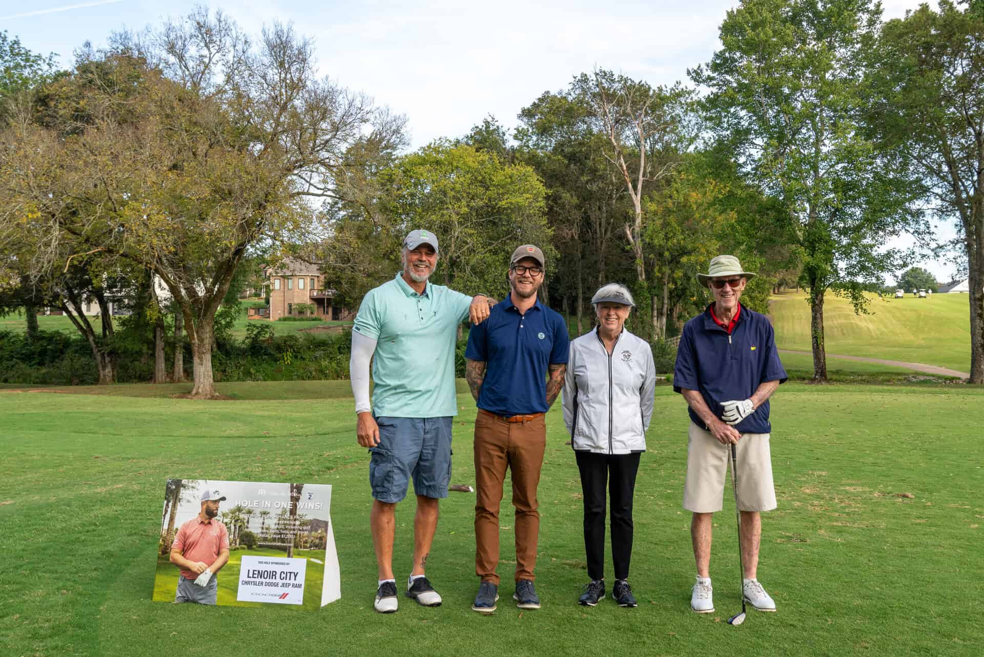 A group of people posing for a picture on a golf course.