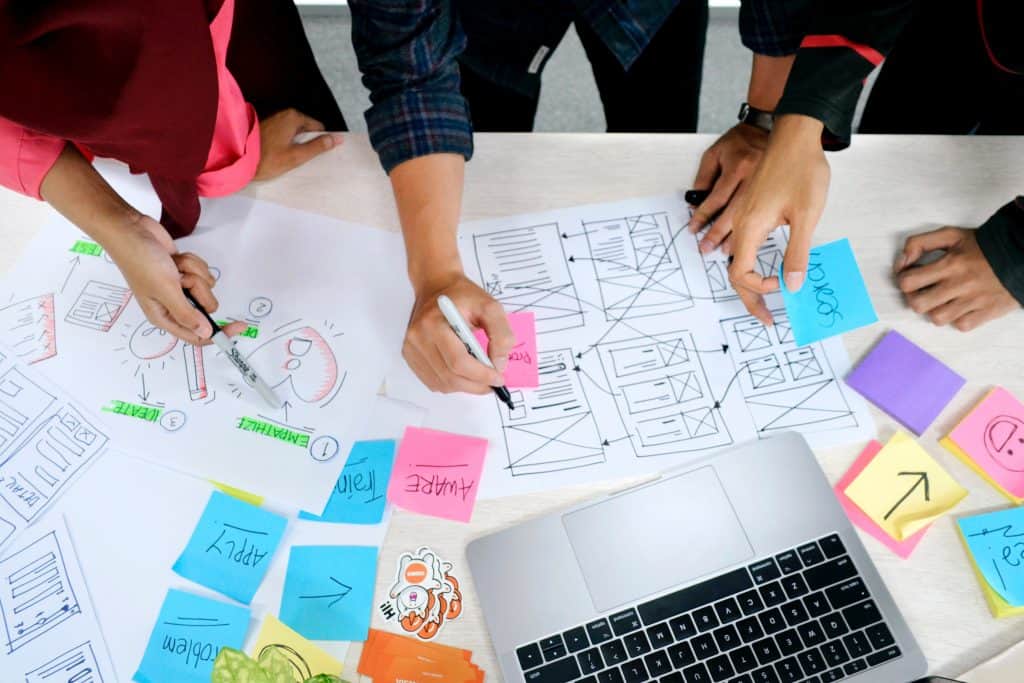 People working surrounded with a laptop and post it notes