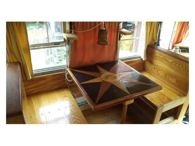 vintage buses-star burst custom table in 1997 Bluebird International full length school bus conversion into a mobile home