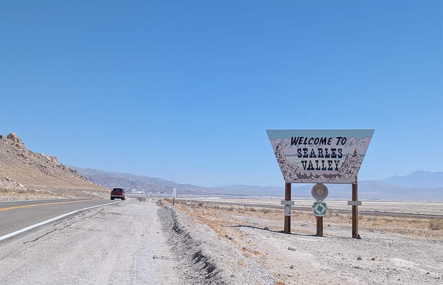 A sign welcomes visitors to the Searles Valley on June 23. The town of Trona and Searles Valley Minerals operations can be seen in the background.