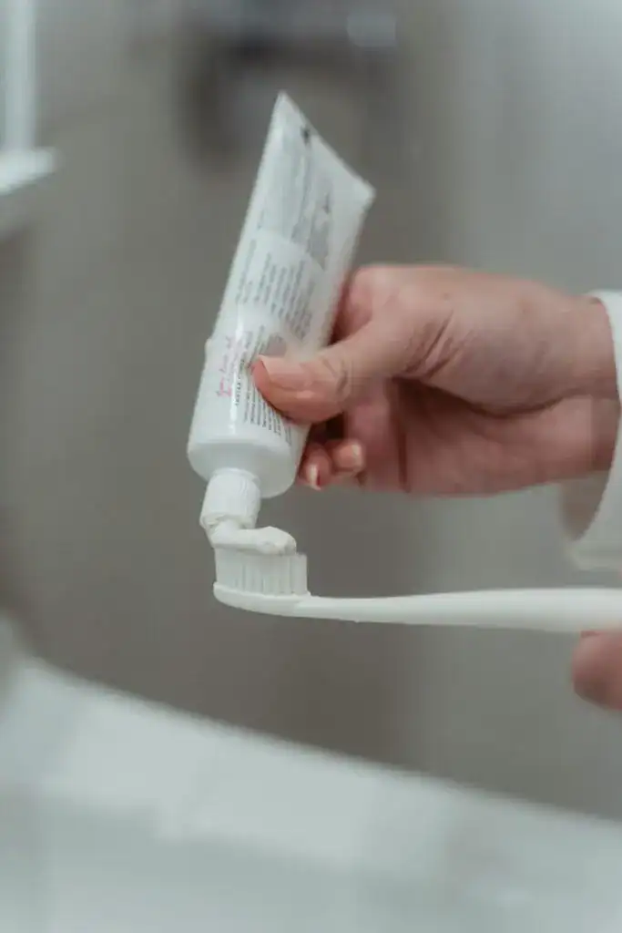 Detailed close-up of toothpaste being applied to a toothbrush, emphasizing hygiene.