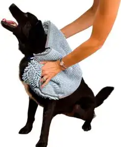 Person drying a black dog using a light blue microfiber pet towel with hand pockets, a practical pet grooming essential for bath time.