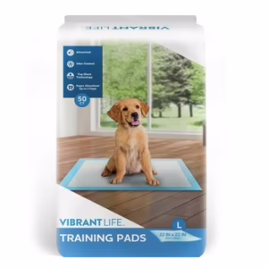 Golden retriever puppy sitting on a training pad, shown on a package of Vibrant Life Training Pads — ideal for potty training and puppy training routines.