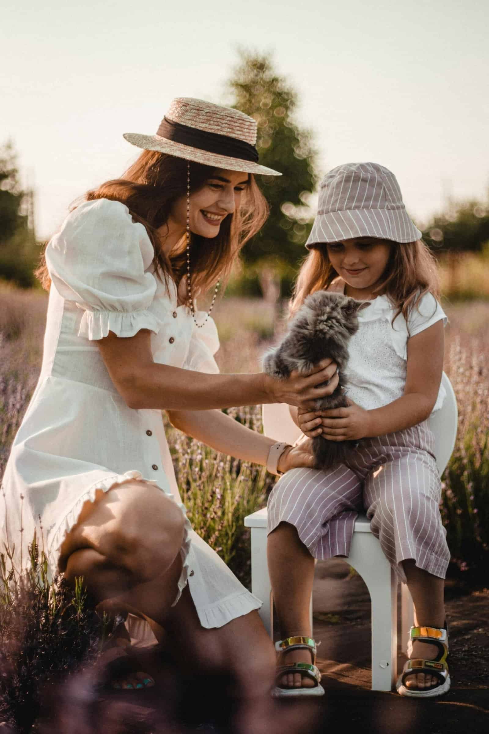 🐾 Finding Everyday Joy: How Pets Inspire Us to Live Better 24 Mother and daughter bonding with a kitten in a sunny outdoor setting.