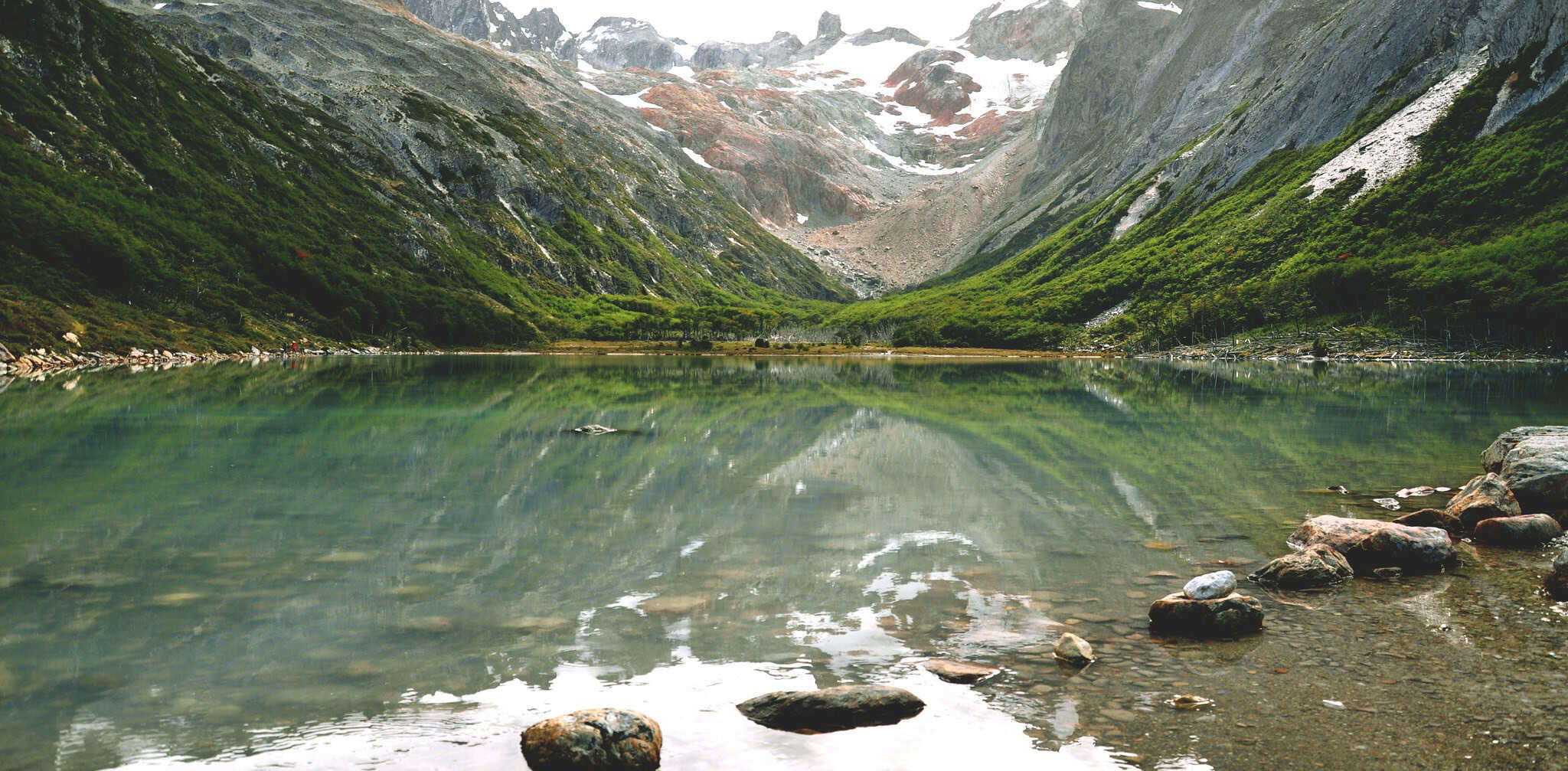 Orilla de Laguna Esmeralda con piedras y glaciares al fondo