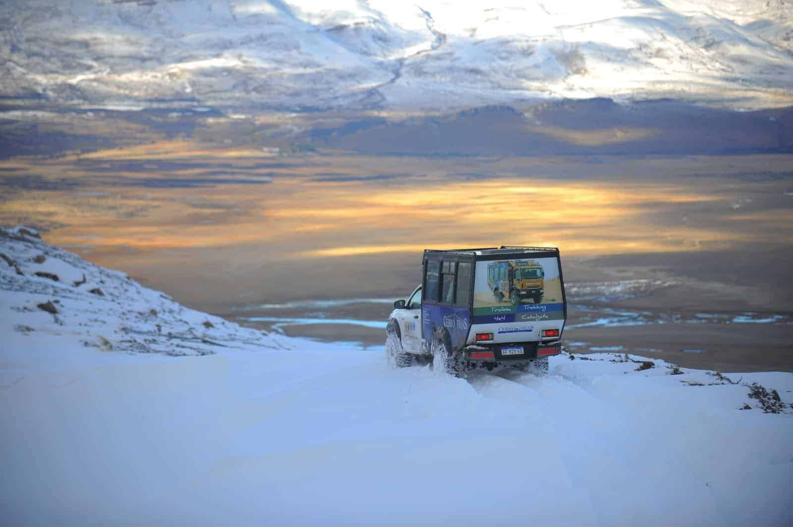 Cerro Frías 4x4 no inverno: veículo sobre a neve ao entardecer em frente ao Lago Argentino