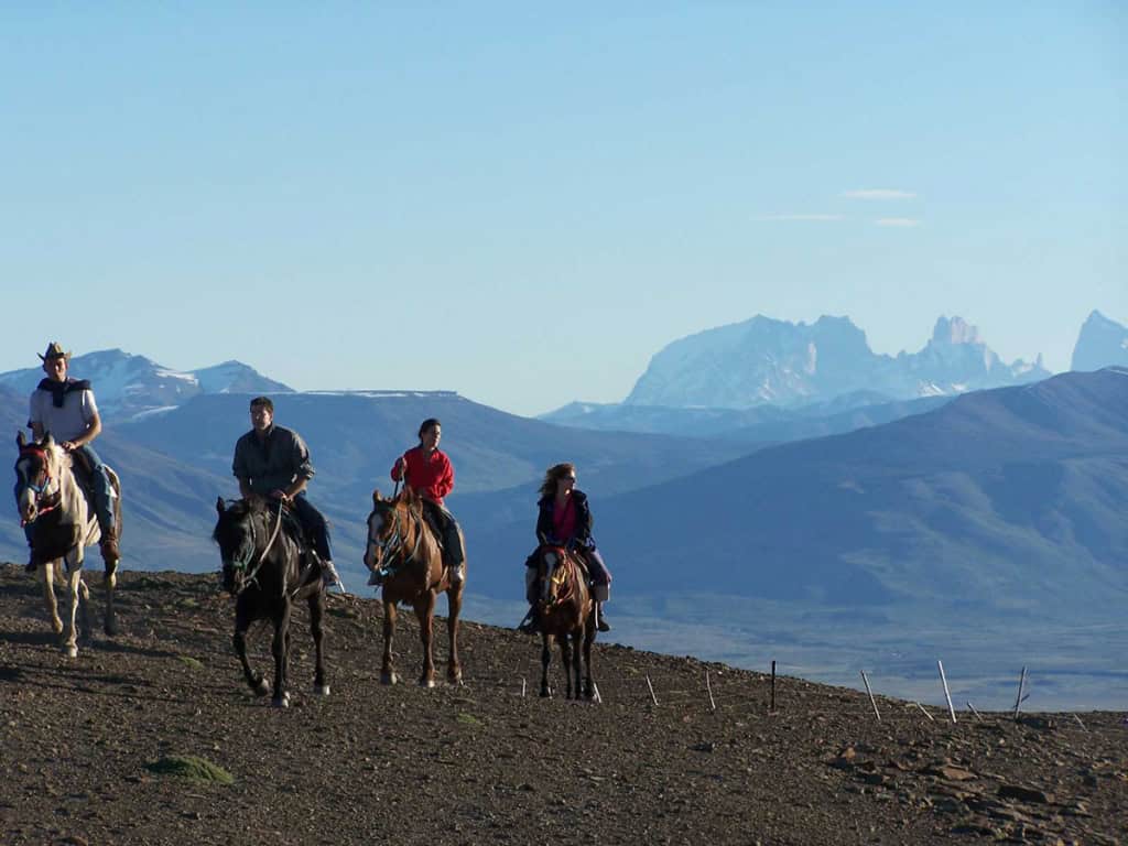 Cavaleiros a cavalo no cume do Cerro Frías com vista às Torres del Paine