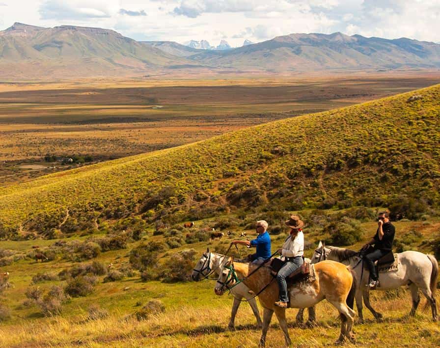 Cavaleiros a cavalo pela estepe dourada do Cerro Frías no outono