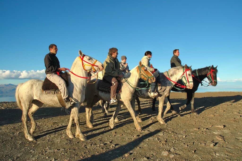 Grupo a cavalo no Cerro Frías com montanhas nevadas ao fundo, El Calafate