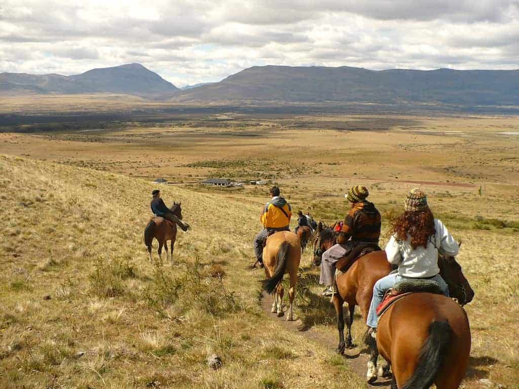 Grupo a cavalo descendo a encosta do Cerro Frías até o Lago Argentino