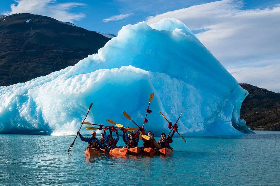 Grupo de caiaques ao lado de um grande iceberg azul, Perito Moreno