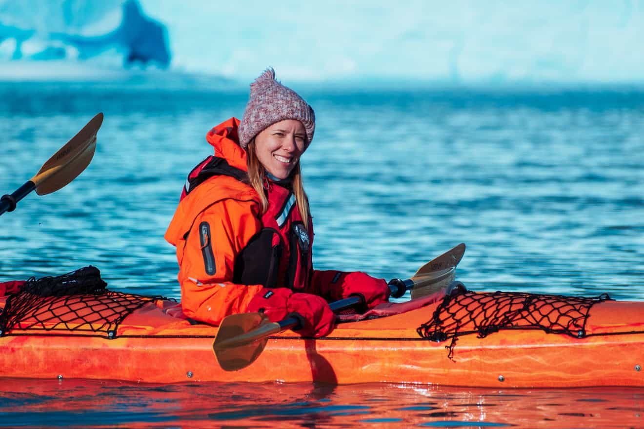 Caiaquista sorrindo durante a travessia em frente ao Perito Moreno