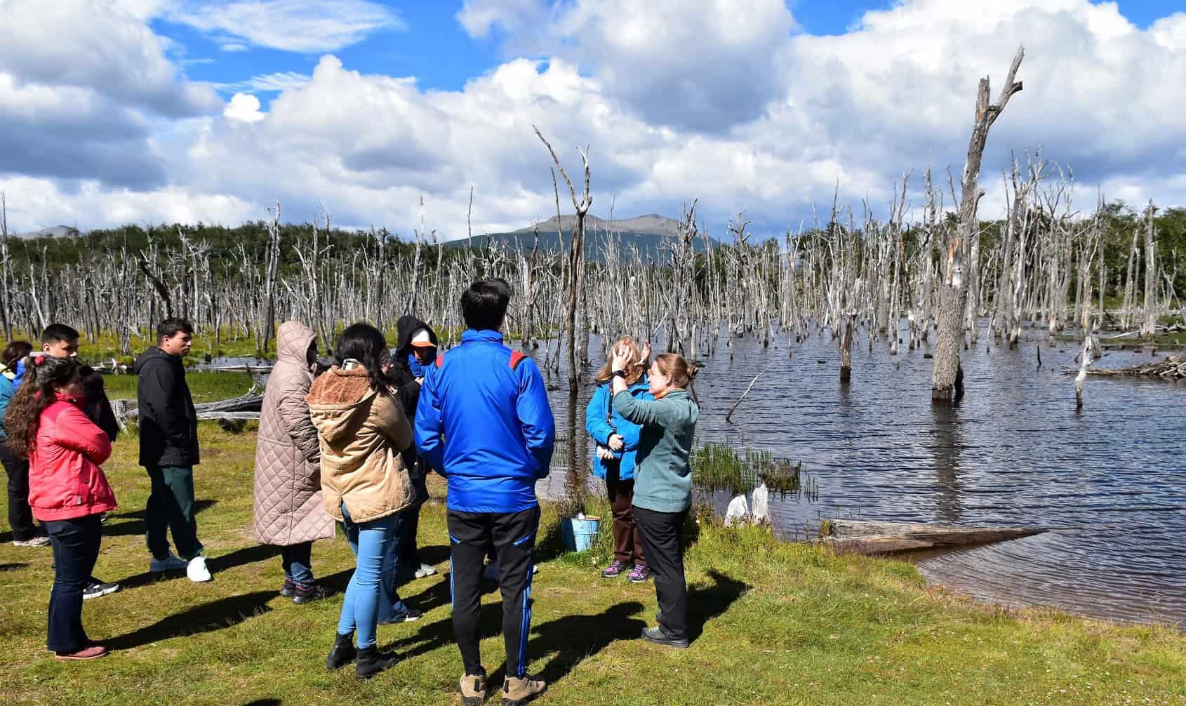Grupo de turistas con guía frente al bosque del Lago Fagnano, Ushuaia