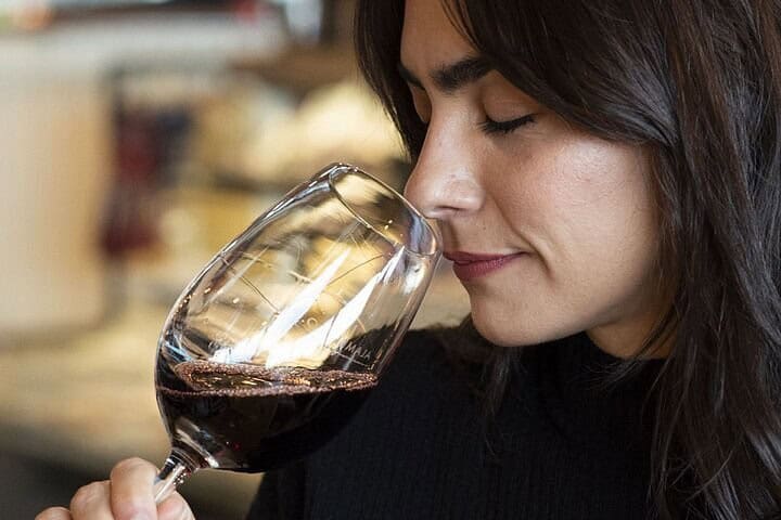 Mulher degustando uma taça de vinho tinto patagônico na degustação City & Wine de Ushuaia
