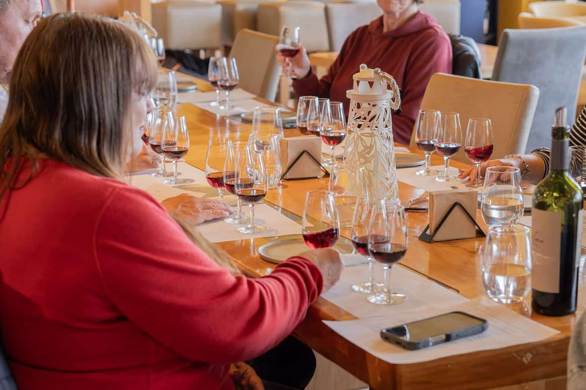 Mesa com taças de vinho tinto na degustação City & Wine de Ushuaia