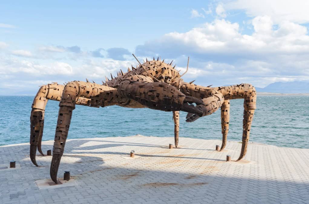 Escultura de centola em frente ao mar no passeio costeiro de Ushuaia