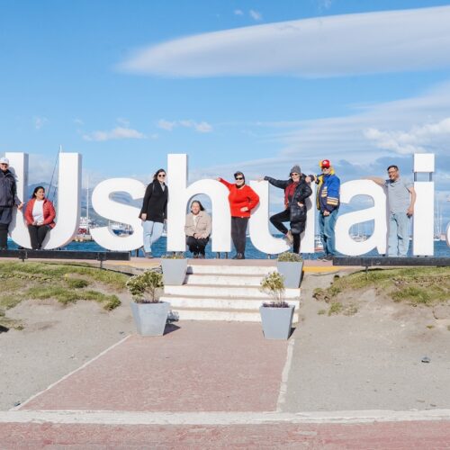 Grupo de pasajeros del City Tour en el cartel de Ushuaia Fin del Mundo