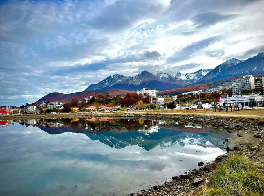 Montanhas de Ushuaia refletidas na água com cores de outono
