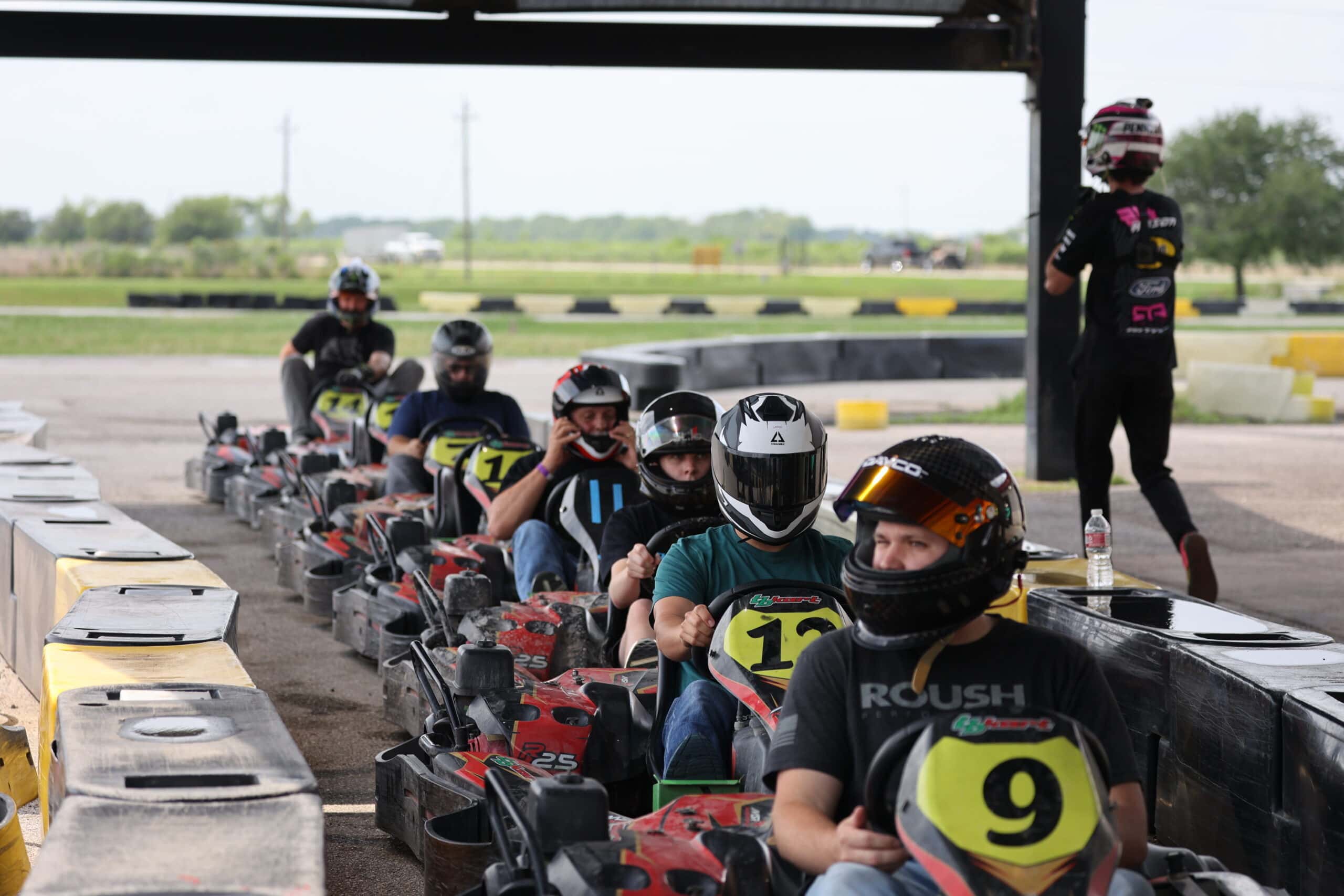 Group of racers in go-karts preparing for race at Mustang Week event.