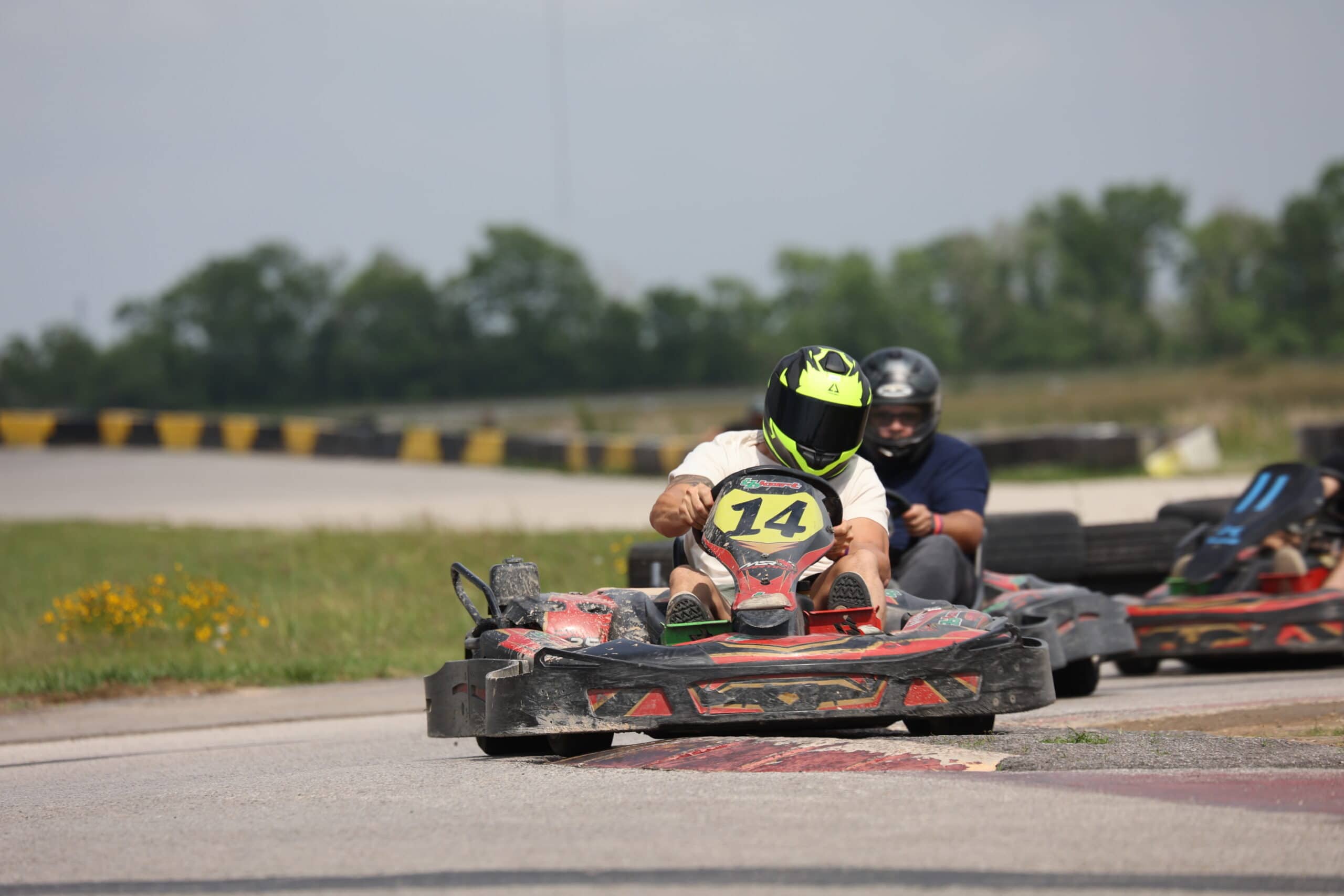 Two racers in go-karts competing on a track during Mustang Week event.