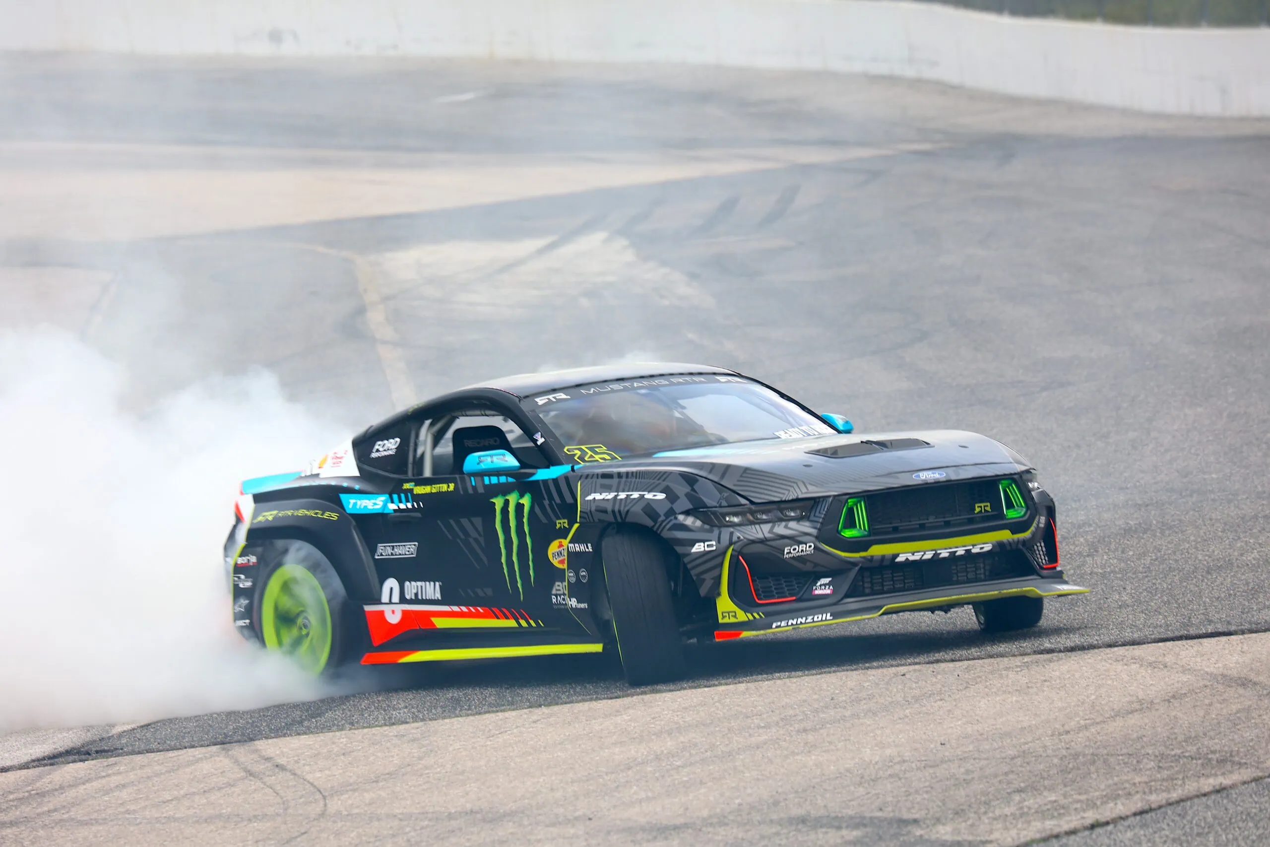 High-performance Mustang drift car on track with smoke and vibrant decals.