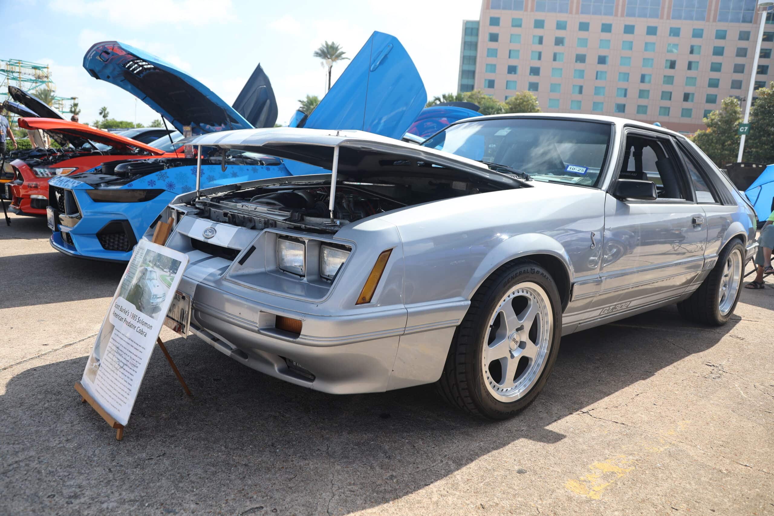 Silver Ford Mustang with open hood at Mustang Week event.