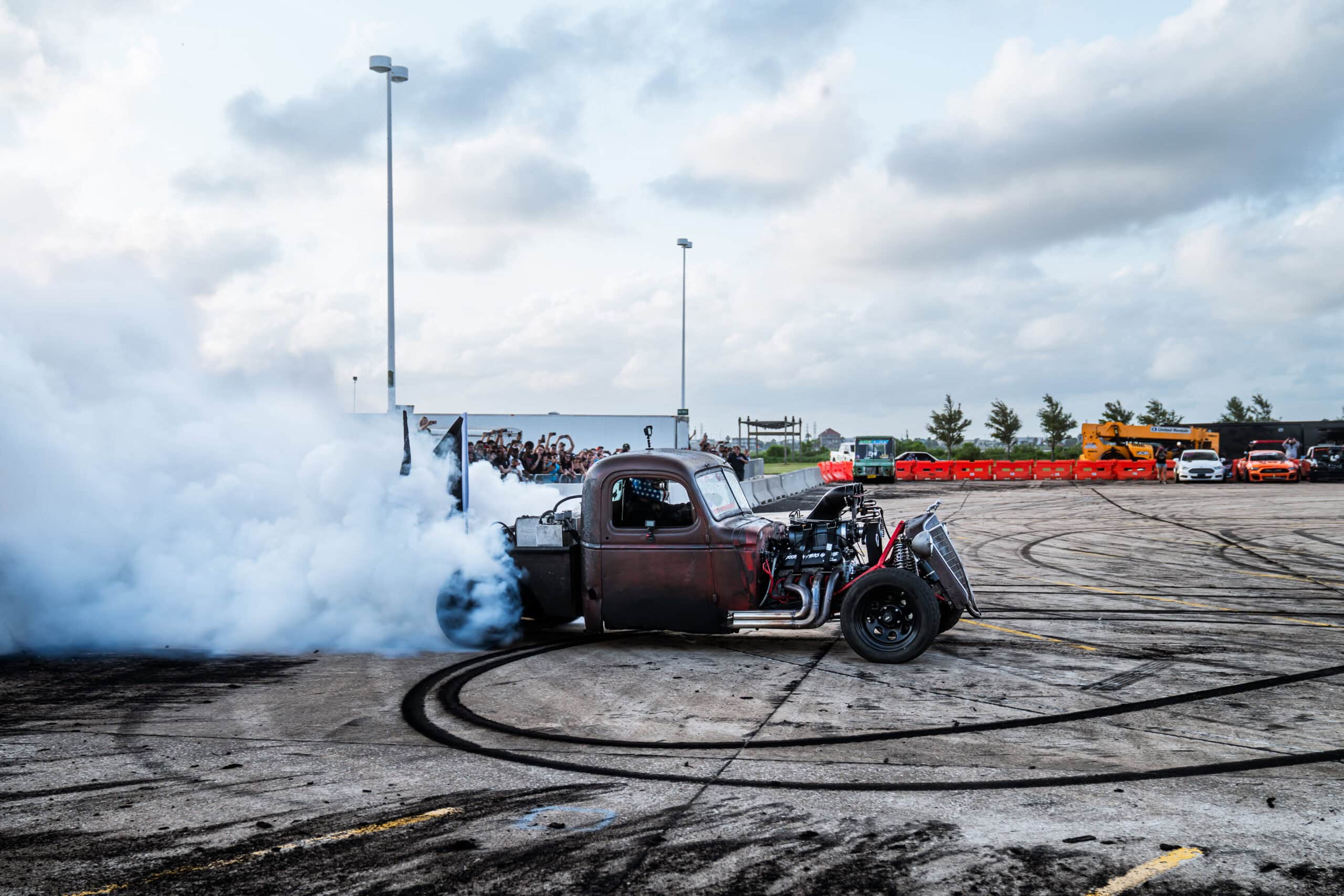Custom hot rod performing burnout at Mustang Week event.