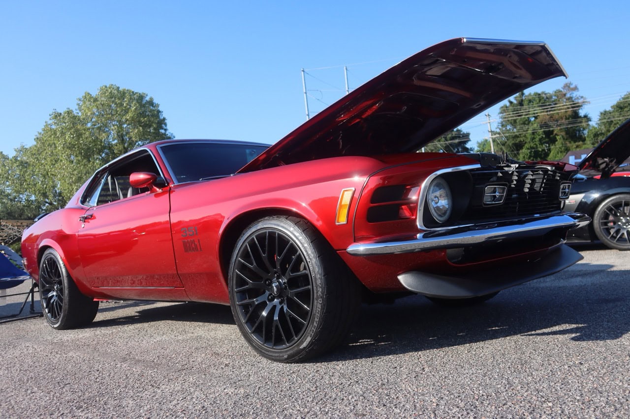 Red 1970s Ford Mustang with open hood at Mustang Week event.