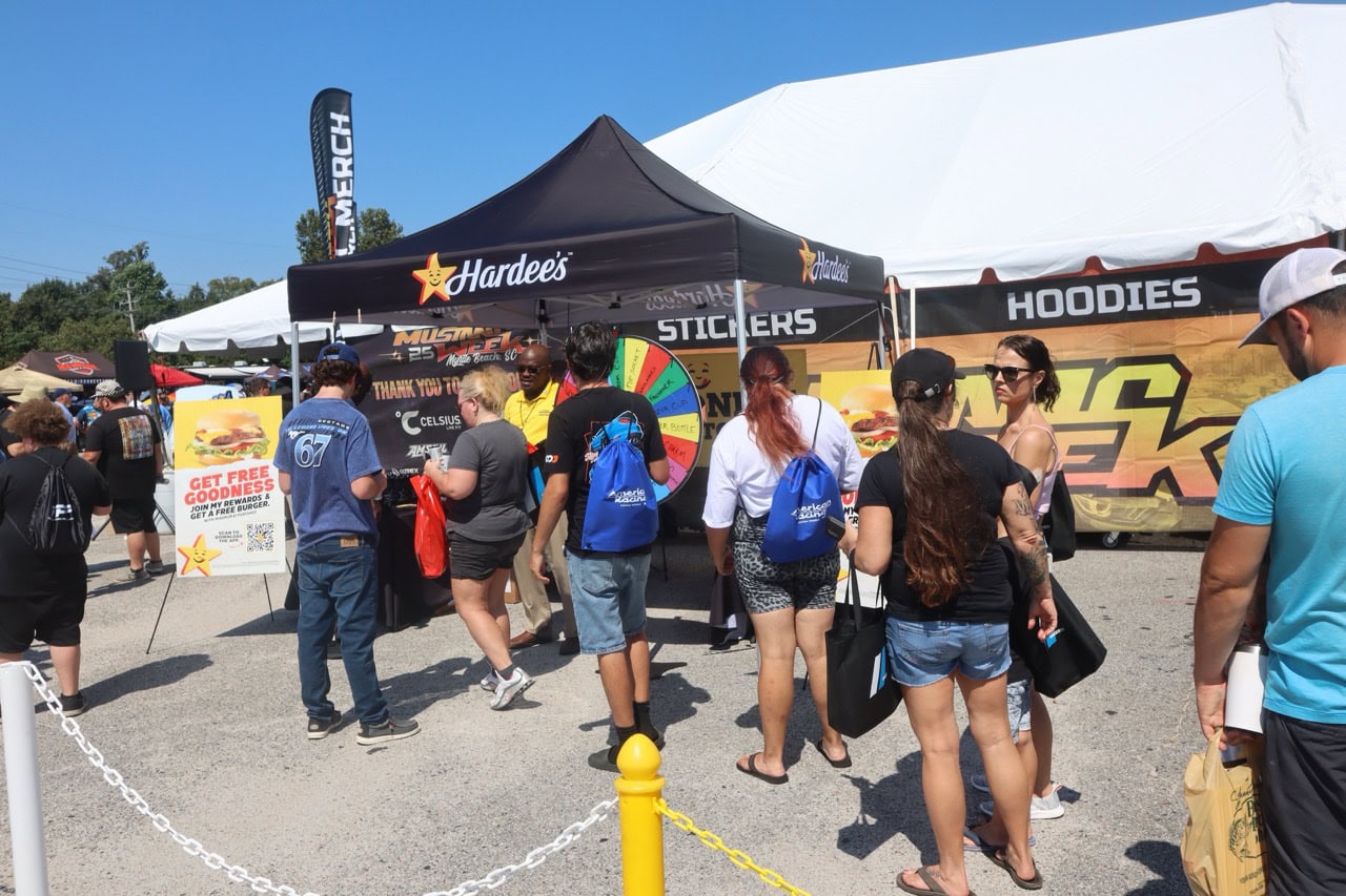 Crowd at Mustang Week event with tents and merchandise booths.