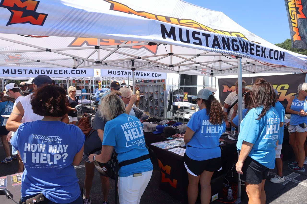 Participants at Mustang Week event in Myrtle Beach with Mustang merchandise and tents.