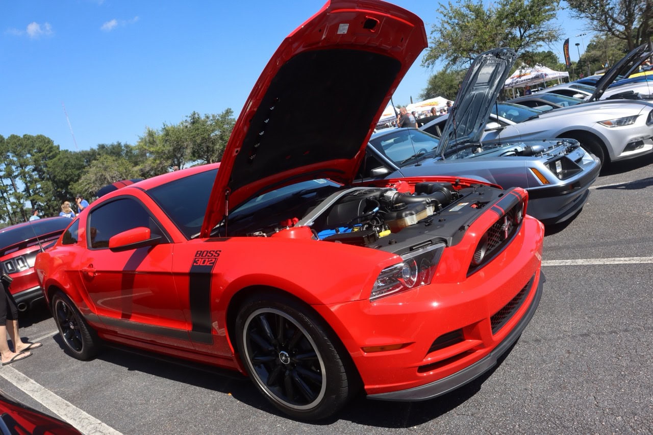 Mustang Week car show in Myrtle Beach 2025 featuring a red Ford Mustang with open hood.