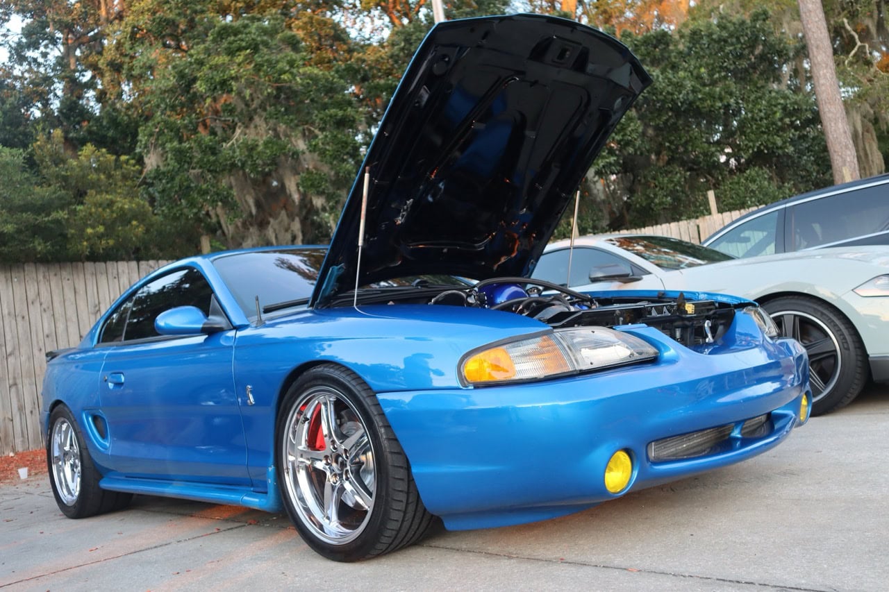 Classic blue Ford Mustang with open hood at Myrtle Beach event.
