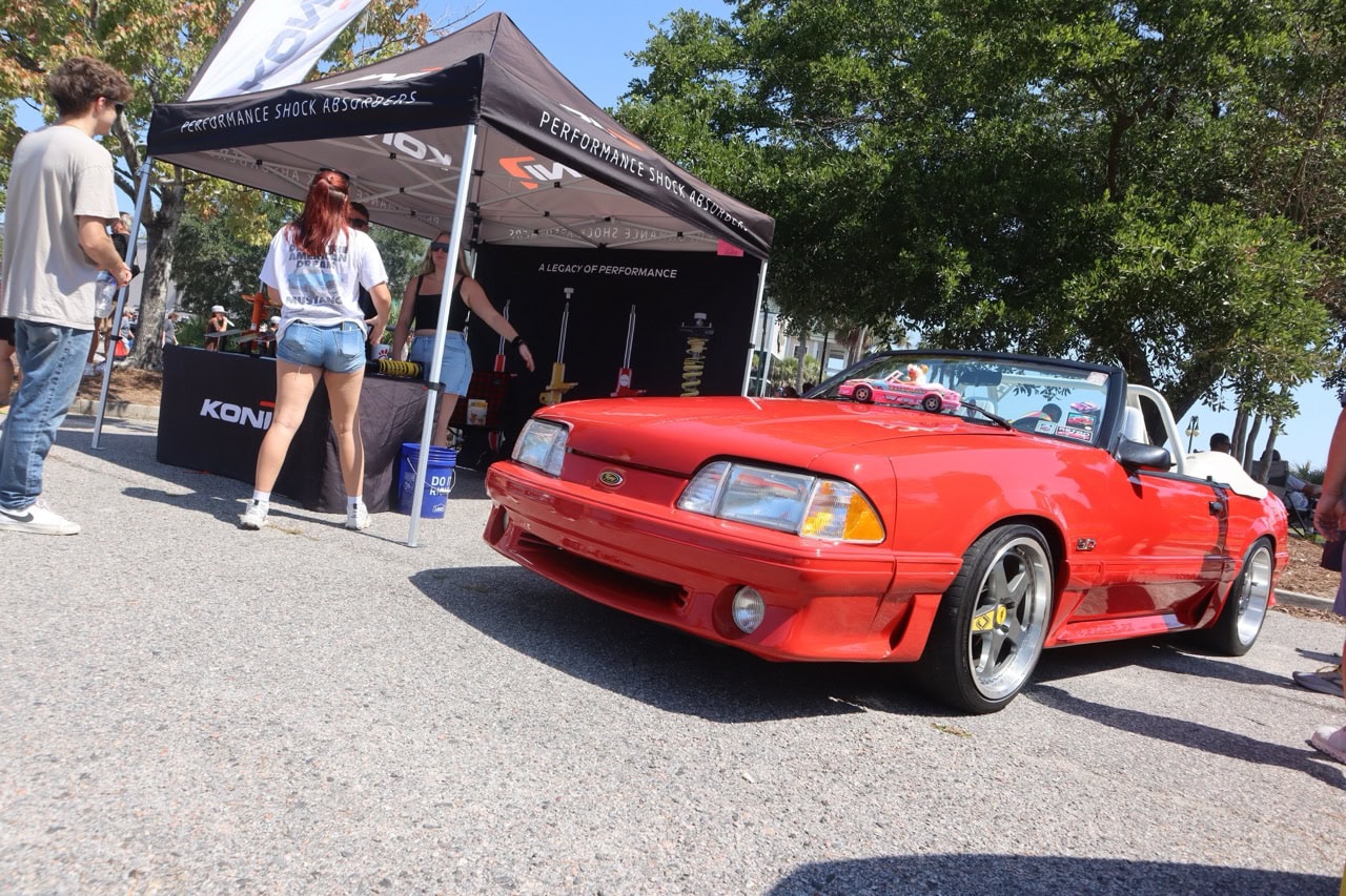 Mustang Week car show at Myrtle Beach 2025 featuring a red Ford Mustang convertible.