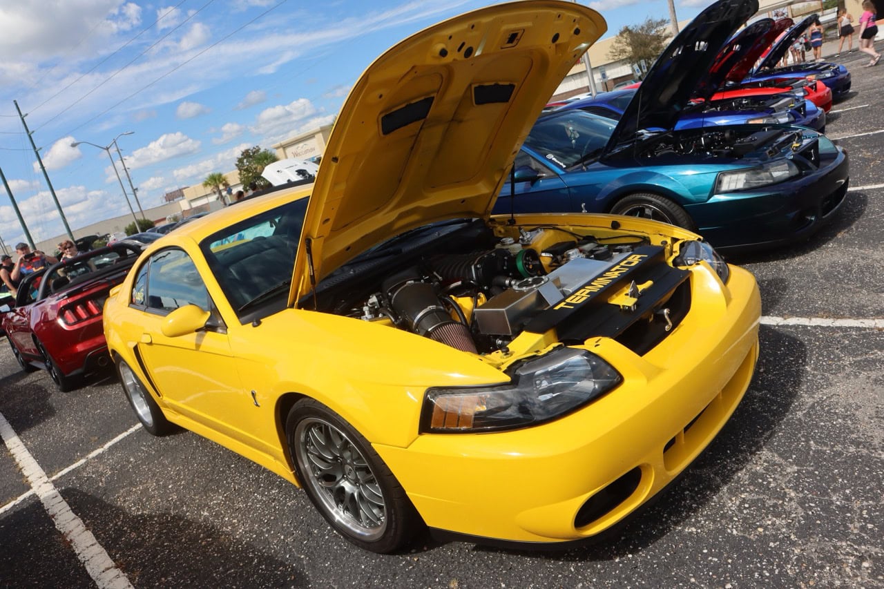 Mustang Week car show in Myrtle Beach 2025 featuring a yellow Ford Mustang with open hood.