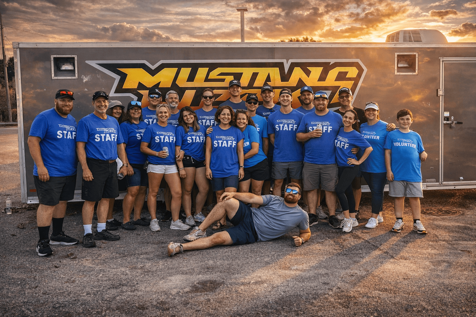 Group of Mustang Week staff members in blue shirts at sunset.